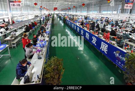 220116 -- YUTIAN, 16 gennaio 2022 -- la foto mostra una vista interna di un laboratorio presso la base di produzione di Erke nel parco industriale di Tianjin nella contea di Yutian, nella regione autonoma di Xinjiang Uygur della Cina nord-occidentale, 13 gennaio 2022. La contea di Yutian, un tempo un'area povera dello Xinjiang, ha intensificato lo sviluppo delle industrie ad alta intensità di lavoro, tra cui tessile, abbigliamento e calzini. Nel parco industriale di Tianjin a Yutian, una base produttiva del marchio sportivo cinese Erke è stata messa in funzione il 1° gennaio 2022, offrendo più di 500 posti di lavoro per la gente del posto. Maynurhan Amang e suo marito Abudulezizi Maisedi Foto Stock