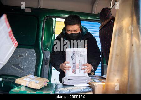 220118 -- SHANXI, 18 gennaio 2022 -- Wan Yuntian organizza giornali in un sito di consegna a Taiyuan, nella provincia dello Shanxi della Cina settentrionale, 5 gennaio 2022. Situato in una remota area montuosa nel distretto di Wanbailin a Taiyuan, la città di Wangfeng soffriva da tempo di infrastrutture di trasporto inadeguate. Nel 1985, Wang Shouqiu divenne un postino della China Post al servizio della municipalità di Wangfeng, e mantenne il suo posto fino a quando non fu trasferito nel 2020 a causa delle sue cattive condizioni di salute. Dal momento della consegna a piedi fino alla consegna tramite furgone postale, Wang Shouqiu si era guadagnato rispetto e fiducia da parte degli abitanti locali con più di 30 anni di Foto Stock