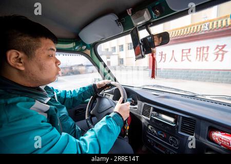 220118 -- SHANXI, 18 gennaio 2022 -- Wan Yuntian guida un furgone postale per consegnare i pacchi nella municipalità di Wangfeng di Taiyuan, nella provincia dello Shanxi della Cina settentrionale, 12 gennaio 2022. Situato in una remota area montuosa nel distretto di Wanbailin a Taiyuan, la città di Wangfeng soffriva da tempo di infrastrutture di trasporto inadeguate. Nel 1985, Wang Shouqiu divenne un postino della China Post al servizio della municipalità di Wangfeng, e mantenne il suo posto fino a quando non fu trasferito nel 2020 a causa delle sue cattive condizioni di salute. Dal momento della consegna a piedi fino alla consegna tramite furgone postale, Wang Shouqiu si era guadagnato rispetto e fiducia da parte degli abitanti locali con m Foto Stock