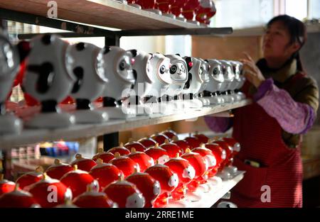 220119 -- DEHUA, 19 gennaio 2022 -- Un operaio mette sullo scaffale di una fabbrica di porcellana nella contea di Quanzhou, nella provincia del Fujian, nel sud-est della Cina, 2022 mascotte di Pechino, nella fabbrica di porcellana di Dehua, 19 gennaio 2022. CHINA-FUJIAN-BEIJING 2022 MASCOTTE-PORCELLANA CN WEIXPEIQUAN PUBLICATIONXNOTXINXCHN Foto Stock