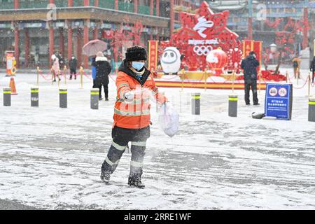 220120 -- PECHINO, 20 gennaio 2022 -- Un operaio sanitario disperde un agente che si scioglie la neve su una strada a Pechino, capitale della Cina, 20 gennaio 2022. CHINA-BEIJING-SNOW CN LixXin PUBLICATIONxNOTxINXCHN Foto Stock