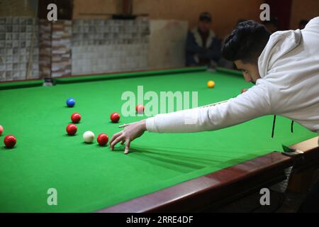 220126 -- GAZA, 26 gennaio 2022 -- il giovane palestinese Ahmed Nasr gioca a snooker all'interno di un club sportivo locale nella città meridionale di Rafah, nella Striscia di Gaza, il 26 gennaio 2022. Nasr, 22 anni, ha imparato a giocare a snooker e a biliardo da suo padre, poi ha imparato le regole del gioco attraverso i video di YouTube. Recentemente ha vinto il primo posto nel campionato di snooker della Striscia di Gaza, che lo ha qualificato per il campionato di classifica a livello della squadra palestinese. Foto di Khaled Omar/Xinhua SPMIDEAST-GAZA-RAFAH-SNOOKER EmadxDrimly PUBLICATIONxNOTxINxCHN Foto Stock
