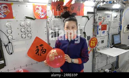 220131 -- PECHINO, 31 gennaio 2022 -- Taikonaut Wang Yaping, vestito con costumi festivi, augura ai bambini di tutta la Cina una crescita vigorosa e sana tenendo in mano un palloncino rosso, in uno screenshot ottenuto da un video. I membri dell'equipaggio di Shenzhou-13 sono diventati i primi cinesi a trascorrere il festival più importante della nazione - il Capodanno lunare cinese - nello spazio. A bordo del modulo centrale della stazione spaziale cinese, a circa 400 km sopra la Terra, i taikonauti Zhai Zhigang, Wang Yaping e Ye Guangfu hanno esteso i loro saluti al Festival di Primavera in un video pubblicato dalla China Manned Space Agency alla vigilia di Capodanno. CINA- Foto Stock