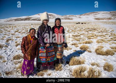 220204 -- LHASA, 4 febbraio 2022 -- Tenzin Drolma C sta con sua madre R e una ragazza vicina mentre allevava bestiame nel villaggio Gyaga della contea di Damxung, regione autonoma del Tibet della Cina sud-occidentale, 18 gennaio 2022. Tenzin Drolma, 21 anni, nacque sulla prateria vicino al lago Namtso in Tibet. Nel 2020 è stata ammessa al Jiangsu Food and Pharmaceutical Science College nella provincia di Jiangsu nella Cina orientale come studente principale di farmacia cinese. La vita universitaria nel mondo esterno è fresca per Drolma. Ha incontrato molti nuovi compagni di classe e si è fatta molti amici. Quando è arrivata la vacanza invernale, Drolma è tornata nella sua amata casa. Foto Stock