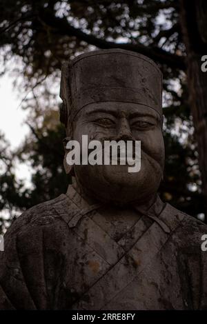 La statua del membro della famiglia Kong in un cimitero cimiteriale per Confucio nella città di Qufu, nella provincia cinese di Shandong, nel tardo pomeriggio. Foto Stock