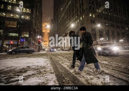 220218 -- CHICAGO, 18 febbraio 2022 -- i cittadini attraversano LaSalle Street mentre l'edificio del Chicago Board of Trade incombe sullo sfondo nel centro di Chicago, negli Stati Uniti, il 17 febbraio 2022. Un sistema di tempeste invernali con forti venti ha colpito gli Stati Uniti centrali giovedì. Foto di /Xinhua U.S.-CHICAGO-WINTER STORM VincentxD.xJohnson PUBLICATIONxNOTxINxCHN Foto Stock