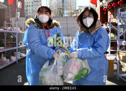 220223 -- PECHINO, 23 febbraio 2022 -- i membri del personale trasportano le necessità quotidiane ordinate dai residenti in un complesso residenziale nel distretto di Fengtai a Pechino, capitale della Cina, 23 febbraio 2022. Pechino ha riportato otto casi confermati di COVID-19 trasmessi localmente dalle 11:00 martedì alle 11:00 mercoledì, le autorità locali hanno detto mercoledì. I casi provengono dall'area di sviluppo economico-tecnologico di Pechino, dal distretto di Chaoyang, dal distretto di Tongzhou, dal distretto di Shunyi e dal distretto di Xicheng, secondo un comunicato stampa tenuto dal governo municipale. CHINA-BEIJING-COVID-19-MEASURES CN RenxChao PUBLICATIONx Foto Stock