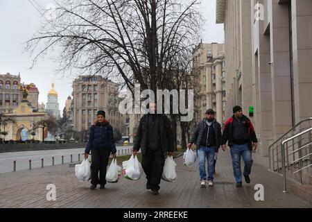 220224 -- KIEV, 24 febbraio 2022 -- i cittadini camminano in una strada dopo aver comprato le necessità quotidiane a Kiev, Ucraina, 24 febbraio 2022. Il presidente ucraino Volodymyr Zelensky ha detto giovedì che Kiev decide di interrompere le relazioni diplomatiche con Mosca dopo che la Russia ha lanciato operazioni militari nel Donbass, l'agenzia di stampa Ukrinform gestita dal governo ha riferito. UCRAINA-KIEV-RUSSIA-RELAZIONI DIPLOMATICHE LixDongxu PUBLICATIONxNOTxINxCHN Foto Stock