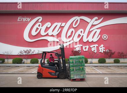 220226 -- SHANGHAI, 26 febbraio 2022 -- Un lavoratore trasferisce merci alla Swire Coca-Cola Beverages Hubei Limited a Wuhan, provincia di Hubei, Cina centrale, 24 marzo 2020. Xinhua titoli: Cinque decenni dopo, il comunicato di Shanghai risuona ancora tra i cinesi, gli americani XiaoxYijiu PUBLICATIONxNOTxINxCHN Foto Stock