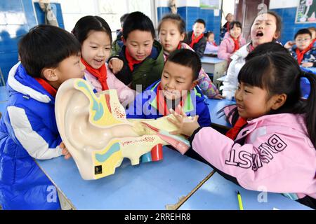 220303 -- ZIGUI, 3 marzo 2022 -- gli studenti apprendono la struttura dell'orecchio attraverso un modello di orecchio in una scuola elementare nella contea di Zigui di Yichang, provincia di Hubei, Cina centrale, 2 marzo 2022. Il 3 marzo segna la giornata nazionale della cura dell'orecchio in Cina. Sono state svolte varie attività per promuovere la sensibilizzazione del pubblico in merito alla protezione dell'udito. Foto di /Xinhua CHINA-EAR CARE DAY-ACTIVITIES CN WangxHuifu PUBLICATIONxNOTxINxCHN Foto Stock