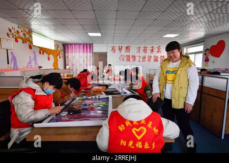 220304 -- TIANJIN, 4 marzo 2022 -- Tian Lichao è visto con i giovani disabili che realizzano dipinti decorativi a punti incrociati in una base di lavoro per i disabili nel distretto di Baodi, nel nord della Cina, a Tianjin, 1 marzo 2022. In un complesso speciale nella città di Shigezhuang, nel distretto di Baodi, 49 giovani disabili con un'età media inferiore ai 23 anni lavorano e vivono qui. Il ritardo mentale, la compromissione della vista e altre disabilità una volta li facevano sentire inferiori. Tuttavia, con l'aiuto di Tian Lichao, stanno diventando sempre più fiduciosi. Un giorno nel 2016, Tian Lichao incontrò una ragazza perduta con disabilità intellettive Foto Stock