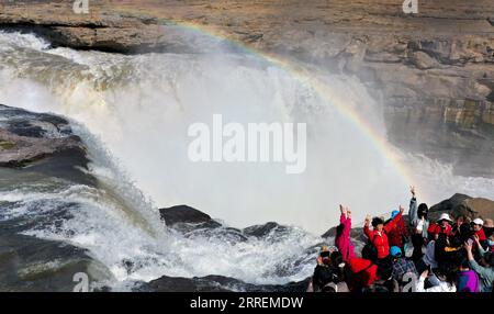 220308 -- YAN AN, 8 marzo 2022 -- foto aerea scattata l'8 marzo 2022 mostra i turisti che guardano il paesaggio della cascata Hukou sul fiume giallo nella provincia dello Shaanxi della Cina nord-occidentale. La cascata hukou sta assistendo ad un aumento del flusso d'acqua a causa della temperatura calda. CHINA-SHAANXI-HUKOU CASCATA-PAESAGGIO CN TAOXMING PUBLICATIONXNOTXINXCHN Foto Stock