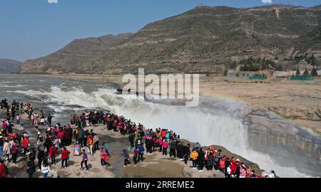 220308 -- YAN AN, 8 marzo 2022 -- foto aerea scattata l'8 marzo 2022 mostra i turisti che guardano il paesaggio della cascata Hukou sul fiume giallo nella provincia dello Shaanxi della Cina nord-occidentale. La cascata hukou sta assistendo ad un aumento del flusso d'acqua a causa della temperatura calda. CHINA-SHAANXI-HUKOU CASCATA-PAESAGGIO CN TAOXMING PUBLICATIONXNOTXINXCHN Foto Stock