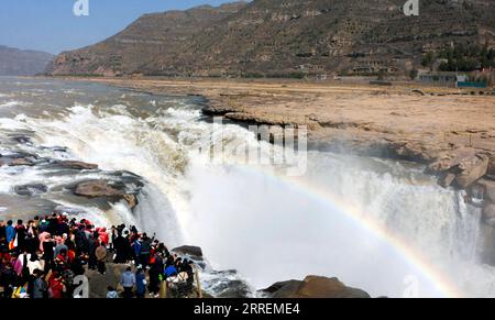 220308 -- YAN AN, 8 marzo 2022 -- foto aerea scattata l'8 marzo 2022 mostra i turisti che guardano il paesaggio della cascata Hukou sul fiume giallo nella provincia dello Shaanxi della Cina nord-occidentale. La cascata hukou sta assistendo ad un aumento del flusso d'acqua a causa della temperatura calda. CHINA-SHAANXI-HUKOU CASCATA-PAESAGGIO CN TAOXMING PUBLICATIONXNOTXINXCHN Foto Stock