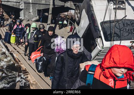 220313 -- IRPIN, 13 marzo 2022 -- persone evacuano a Irpin, Ucraina, 11 marzo 2022. L'Ucraina ha istituito 12 corridoi umanitari in quattro regioni venerdì per consentire ai civili di lasciare le aree dilaniate dal conflitto, ha riferito l'agenzia di stampa Ukrinform gestita dal governo ucraino, citando il vice primo ministro ucraino Iryna Vereshchuk. I corridoi umanitari sono stati creati per evacuare persone da alcune città e città nella parte orientale di Donetsk e Charkiv, Zaporizhzhya meridionale e Kiev centro-settentrionale, Vereshchuk Said. Foto di /Xinhua UCRAINA-IRPIN-CONFLITTO-CORRIDOI UMANITARI-EVACUAZIONE DiegoxHerrera PUB Foto Stock