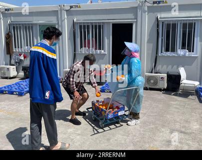 220314 -- HONG KONG, 14 marzo 2022 -- la foto scattata con un telefono cellulare mostra un membro dello staff medico che distribuisce frutta in una struttura di isolamento della comunità nel sud della Cina a Hong Kong, 12 marzo 2022. Sì, il suo negativo: Un diario del paziente presso la struttura di isolamento per COVID-19 di Hong Kong CINA-HONG KONG-STRUTTURA DI ISOLAMENTO CN Xinhua PUBLICATIONxNOTxINxCHN Foto Stock
