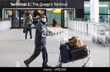 220319 -- LONDRA, 19 marzo 2022 -- i passeggeri camminano all'aeroporto di Heathrow a Londra, in Gran Bretagna, 18 marzo 2022. Il governo britannico ha rimosso tutte le rimanenti restrizioni COVID sui viaggi internazionali per tutti i passeggeri dalle 4:00 ora locale di venerdì. BRITAIN-COVID-19-RESTRICTIONS-REMOVAL LixYing PUBLICATIONxNOTxINxCHN Foto Stock