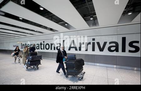 220319 -- LONDRA, 19 marzo 2022 -- i passeggeri camminano nell'area degli arrivi internazionali dell'aeroporto di Heathrow a Londra, in Gran Bretagna, 18 marzo 2022. Il governo britannico ha rimosso tutte le rimanenti restrizioni COVID sui viaggi internazionali per tutti i passeggeri dalle 4:00 ora locale di venerdì. BRITAIN-COVID-19-RESTRICTIONS-REMOVAL LixYing PUBLICATIONxNOTxINxCHN Foto Stock