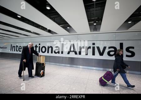 220319 -- LONDRA, 19 marzo 2022 -- i passeggeri camminano nell'area degli arrivi internazionali dell'aeroporto di Heathrow a Londra, in Gran Bretagna, 18 marzo 2022. Il governo britannico ha rimosso tutte le rimanenti restrizioni COVID sui viaggi internazionali per tutti i passeggeri dalle 4:00 ora locale di venerdì. BRITAIN-COVID-19-RESTRICTIONS-REMOVAL LixYing PUBLICATIONxNOTxINxCHN Foto Stock