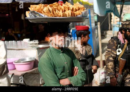 220322 - KABUL, 22 marzo 2022 - un ragazzo afgano vende Samosa vicino al santuario Sakhi durante la celebrazione del festival annuale Nawroz a Kabul, capitale dell'Afghanistan, 21 marzo 2022. Foto di /Xinhua AFGHANISTAN-KABUL-NAWROZ-CELEBRATION SaifurahmanxSafi PUBLICATIONxNOTxINxCHN Foto Stock