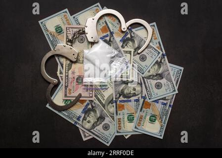 Manette, soldi e cocaina su sfondo oscuro da vicino Foto Stock