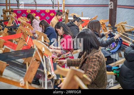 220322 -- CHONGQING, 22 marzo 2022 -- le donne fanno prodotti di Xilankapu, che è una sorta di broccato Tujia, in uno studio nella città di Xiaonanhai nel distretto di Qianjiang nel sud-ovest della Cina, a Chongqing, 22 marzo 2022. Xilankapu, noto anche come abiti da letto floreali a maglia, è stato elencato come patrimonio culturale immateriale nazionale nel 2006. CHINA-CHONGQING-TUJIA BROCADE CN HuangxWei PUBLICATIONxNOTxINxCHN Foto Stock