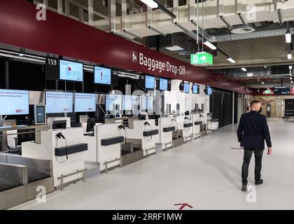 220323 -- SCHOENEFELD, 23 marzo 2022 -- Un membro del personale passa davanti ai banchi di check-in del Terminal 2 dell'aeroporto di Berlino-Brandeburgo a Schoenefeld, Germania, il 23 marzo 2022. Il Terminal 2 dell'aeroporto di Berlino-Brandeburgo aprirà al pubblico il 24 marzo. Foto di /Xinhua GERMANIA-SCHOENEFELD-BERLINO-BRANDEBURGO AEROPORTO-TERMINAL 2 StefanxZeitz PUBLICATIONxNOTxINxCHN Foto Stock