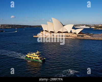 Sydney Australia / Un traghetto per pendolari di Sydney passa per la Sydney Opera House. Lo Scarborough, un traghetto per pendolari, si dirige a Circular Quay a Sydney, Australia Foto Stock