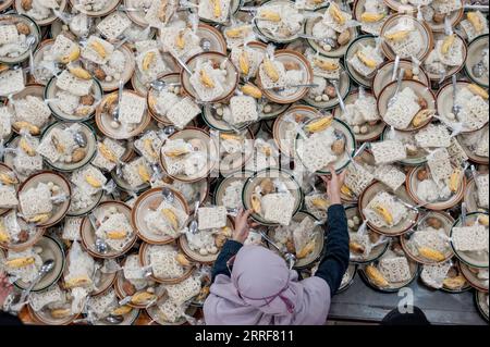 220403 -- YOGYAKARTA, 3 aprile 2022 -- Una donna prepara il porridge per Iftar, il pasto mangiato dai musulmani per rompere il loro digiuno dopo il tramonto durante il Ramadan, alla Moschea Jogokariyan a Yogyakarta, Indonesia, 3 aprile 2022. Foto di /Xinhua INDONESIA-YOGYAKARTA-PORRIDGE-RAMADAN AgungxSupriyanto PUBLICATIONxNOTxINxCHN Foto Stock