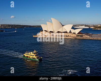 Sydney Australia / Un traghetto per pendolari di Sydney passa per la Sydney Opera House. Lo Scarborough, un traghetto per pendolari, si dirige a Circular Quay a Sydney, Australia Foto Stock