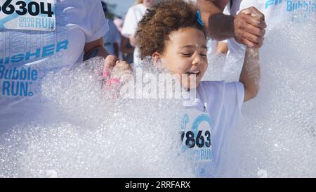 220410 -- POMONA, 10 aprile 2022 -- Un bambino partecipa alla Bubble Run a Pomona, Los Angeles County, California, Stati Uniti, 9 aprile, 2022. migliaia di persone hanno partecipato a una Bubble Run annuale di cinque chilometri a Pomona, nella California meridionale, sabato. Foto di /Xinhua U.S.-CALIFORNIA-POMONA-BUBBLE RUN ZengxHui PUBLICATIONxNOTxINxCHN Foto Stock