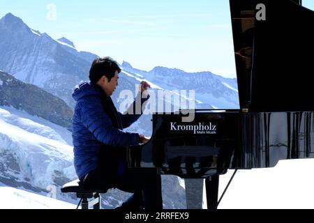 220415 -- INTERLAKEN, 15 aprile 2022 -- il pianista cinese Lang Lang esegue una performance di pianoforte solista a Jungfraujoch, la stazione ferroviaria più alta d'Europa, a Interlaken, in Svizzera, 14 aprile 2022. Nota località panoramica e località di villeggiatura sportiva sulla neve, la Jungfrau è una delle vette principali delle Alpi Bernesi, a 4.158 metri di altezza sul livello del mare. Nel 2001, l'UNESCO ha dichiarato le Alpi svizzere Jungfrau-Aletsch patrimonio dell'umanità. SVIZZERA-INTERLAKEN-JUNGFRAUJOCH-LANG LANG-PIANISTA CHENXBINJIE PUBLICATIONXNOTXINXCHN Foto Stock