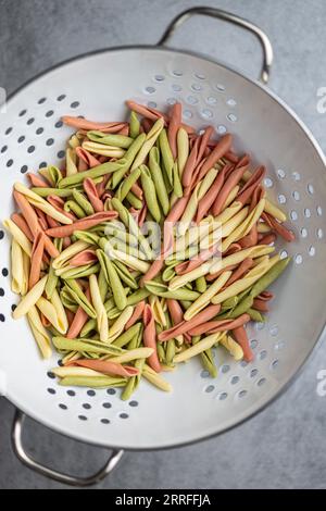 Fusilli pugliesi. Pasta tricolore italiana contorta nel colino. Vista dall'alto. Foto Stock