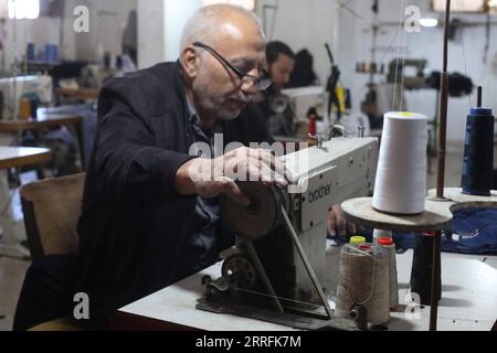 220420 -- RAFAH, 20 aprile 2022 -- Un sarto palestinese prepara vestiti per il prossimo festival Eid al-Fitr in una fabbrica di cucito nella città meridionale di Rafah, nella Striscia di Gaza, il 20 aprile 2022. Foto di /Xinhua MIDEAST-GAZA-RAFAH-SEWING-FACTORY-FESTIVAL KhaledxOmar PUBLICATIONxNOTxINxCHN Foto Stock