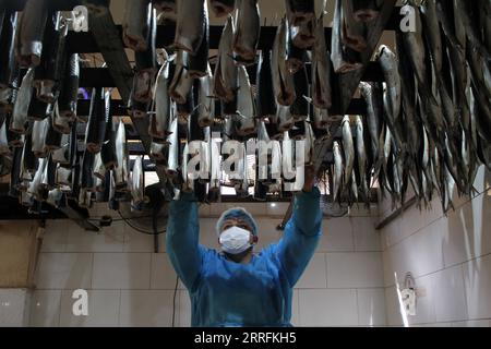 220420 -- GAZA, 20 aprile 2022 -- Un uomo palestinese prepara pesce affumicato in un mercato davanti a Eid al-Fitr nella città meridionale della Striscia di Gaza di Rafah, il 20 aprile 2022. Foto di /Xinhua MIDEAST-GAZA-RAFAH-EID AL-FITR-PREPARATION RizekxAbdeljawad PUBLICATIONxNOTxINxCHN Foto Stock