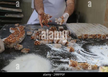 220422 -- RAFAH, 22 aprile 2022 -- Un lavoratore fa dolci turchi o holkum davanti all'Eid al-Fitr, che segna la fine del mese sacro islamico del Ramadan, in un negozio di dolci nella Striscia di Gaza meridionale, nella città di Rafah, 22 aprile 2022. Foto di /Xinhua MIDEAST-GAZA-RAFAH-TURCO DOLCE KhaledxOmar PUBLICATIONxNOTxINxCHN Foto Stock