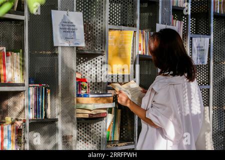 220423 -- MANILA, 23 aprile 2022 -- Una donna legge un libro alla fermata del libro in una piazza durante la giornata mondiale del libro a Manila, nelle Filippine, il 23 aprile 2022. The Book Stop in Manila è una libreria pop-up con lo slogan "Give a book, Get a book to incoraggia le persone a leggere e promuovere la condivisione di idee attraverso la ridistribuzione dei libri". FILIPPINE-MANILA-WORLD BOOK DAY-POP-UP LIBRARY ROUELLEXUMALI PUBLICATIONXNOTXINXCHN Foto Stock