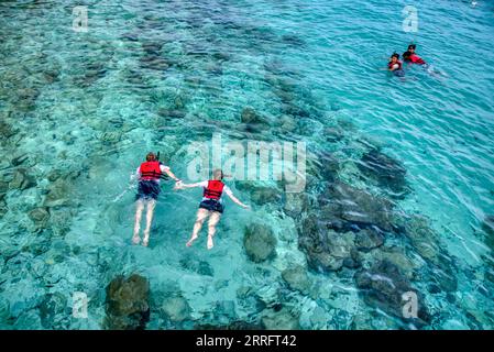 Attività di snorkeling di coppia irriconoscibile nel mare cristallino Foto Stock