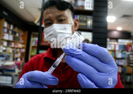 220426 -- SURABAYA, 26 aprile 2022 -- Un operatore sanitario prepara una dose di richiamo del vaccino anti COVID-19 al Gramedia Book Store di Surabaya, Giava Orientale, Indonesia, 26 aprile 2022. Le autorità hanno stimato che quest'anno 85 milioni di persone avrebbero fatto viaggi verso casa per le festività natalizie di Eid al-Fitr, con viaggiatori di età pari o superiore a 18 anni che dovevano ricevere scatti di richiamo. Foto di /Xinhua INDONESIA-SURABAYA-COVID-19-BOOSTER-VACCINATION Kurniawan PUBLICATIONxNOTxINxCHN Foto Stock