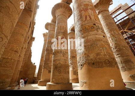 220428 -- CAIRO, 28 aprile 2022 -- i turisti visitano enormi colonne al complesso del Tempio di Karnak a Luxor, Egitto, 27 aprile 2022. Luxor, una capitale dell'antico alto Egitto conosciuta come Tebe, è ora una destinazione turistica famosa per gli edifici storici dei templi e altre reliquie. EGITTO-LUXOR-MONUMENTI STORICI-TURISMO SuixXiankai PUBLICATIONxNOTxINxCHN Foto Stock