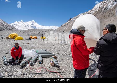 220503 -- CAMPO BASE DEL MONTE QOMOLANGMA, 3 maggio 2022 -- i membri della ricerca scientifica gonfiano una mongolfiera meteorologica al campo base del monte Qomolangma il 3 maggio 2022. La Cina ha avviato una nuova spedizione scientifica completa sul Monte Qomolangma, la vetta più alta del mondo al confine tra Cina e Nepal. Fattori meteorologici quali temperatura, velocità del vento e umidità influenzeranno direttamente il completamento delle attività di ricerca scientifica e la sicurezza del personale di ricerca ad altitudini elevate. Pertanto, è stato lanciato un team di supporto meteorologico per salvaguardare la spedizione scientifica. Il team è composto da st Foto Stock