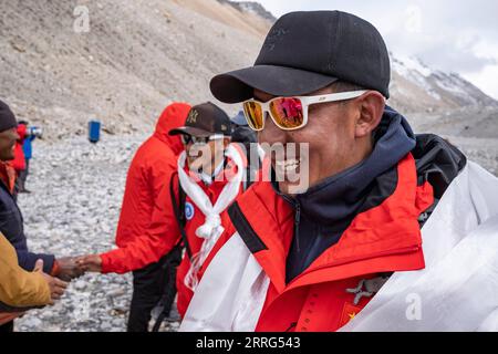 220509 -- MOUNT QOMOLANGMA BASE CAMP, 9 maggio 2022 -- Dechen Ngodrup e i suoi compagni di squadra tornano sano e salvo al campo base del Monte Qomolangma il 5 maggio 2022. Mercoledì, 13 membri di una spedizione cinese hanno raggiunto la vetta della vetta più alta del mondo, con un'altezza di 8.848,86 metri. La squadra ha istituito una stazione di monitoraggio meteorologico automatica ad un'altitudine di 8.830 metri, la più alta del mondo nel suo genere. Hanno anche misurato lo spessore del ghiaccio e della neve utilizzando un radar ad alta precisione e raccolto campioni per ulteriori ricerche in cima. Dechen Ngodrup, capo della squadra che aveva raggiunto Foto Stock