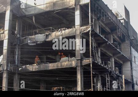 220514 -- NUOVA DELHI, 14 maggio 2022 -- i membri della National Disaster Response Force ispezionano un edificio commerciale sbucciato dopo un enorme incendio a nuova Delhi, India, 14 maggio 2022. Almeno 27 persone sono rimaste uccise e altre 12 hanno subito ferite da ustioni dopo che è scoppiato un enorme incendio in un edificio commerciale a tre piani nella capitale indiana, ha detto sabato l'ufficiale di polizia senior Sameer Sharma. Foto di /Xinhua INDIA-NUOVA DELHI-EDIFICIO COMMERCIALE-MASSICCIO INCENDIO JavedxDar PUBLICATIONxNOTxINxCHN Foto Stock