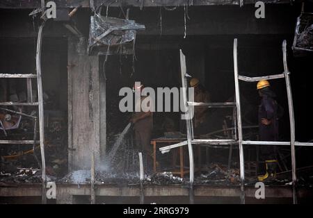 220514 -- NUOVA DELHI, 14 maggio 2022 -- Un fronte di pompieri raddoppia i detriti di un edificio commerciale sbucciato dopo un enorme incendio a nuova Delhi, India, 14 maggio 2022. Almeno 27 persone sono rimaste uccise e altre 12 hanno subito ferite da ustioni dopo che è scoppiato un enorme incendio in un edificio commerciale a tre piani nella capitale indiana, ha detto sabato l'ufficiale di polizia senior Sameer Sharma. Foto di /Xinhua INDIA-NUOVA DELHI-EDIFICIO COMMERCIALE-MASSICCIO INCENDIO JavedxDar PUBLICATIONxNOTxINxCHN Foto Stock
