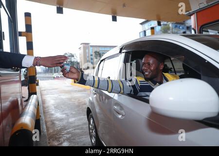 220514 -- NAIROBI, 14 maggio 2022 -- Un autista paga una tassa in una stazione a pedaggio a Nairobi, Kenya, 14 maggio 2022. La Nairobi Expressway, lunga 27 km, è stata finanziata e costruita dalla China Road and Bridge Corporation nell'ambito di un modello di partnership pubblico-privato ed è costituita da due corsie a quattro e sei corsie. Sabato viene lanciata una prova dell'autostrada. PER ANDARE CON LA superstrada costruita in Cina per potenziare il settore turistico del Kenya: PROVA ufficiale DELLA SUPERSTRADA COSTRUITA IN KENYA-NAIROBI-CINESE LongxLei PUBLICATIONxNOTxINxCHN Foto Stock