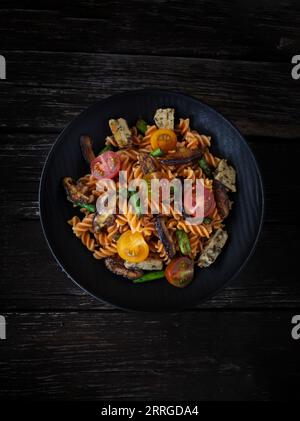 Fusilli con funghi, asparagi e pomodori ciliegini Foto Stock