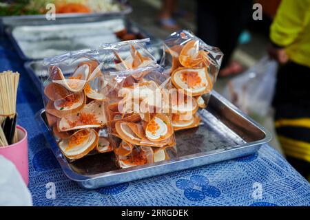 Pancake croccante tailandese in sacchetto di plastica in vendita al mercato di strada Foto Stock