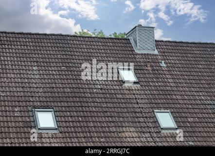 Finestrino del tetto in stile Velux con piastrelle del tetto scure Foto Stock