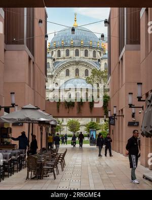 Istanbul, Turchia - 5 maggio 2023: Moschea ottomana imperiale di Nusretiye incorniciata da un passaggio interno a Galataport, uno sviluppo a uso misto situato lungo la riva dello stretto del Bosforo, nel distretto di Karakoy Foto Stock