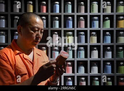 220527 -- XINMI, 27 maggio 2022 -- Cheng Yucai seleziona il dyestuff presso il suo laboratorio a Xinmi City, nella provincia di Henan, nella Cina centrale, il 24 maggio 2022. Il guilloche è una tecnica decorativa in cui un modello preciso, intricato e ripetitivo viene inciso meccanicamente in un materiale tramite la rotazione del motore. La tecnica utilizza una macchina controllata dalla delicatezza della mano dell'artigiano. Come un processo importante nella realizzazione di orologi e gioielli di qualità superiore, l'arte è ora padroneggiata da poche persone. Cheng Yucai, nato nel 1978, conobbe Guilloche nel 2013, quando vide una cassa per sigarette decorata con la tecnica. Lui Foto Stock